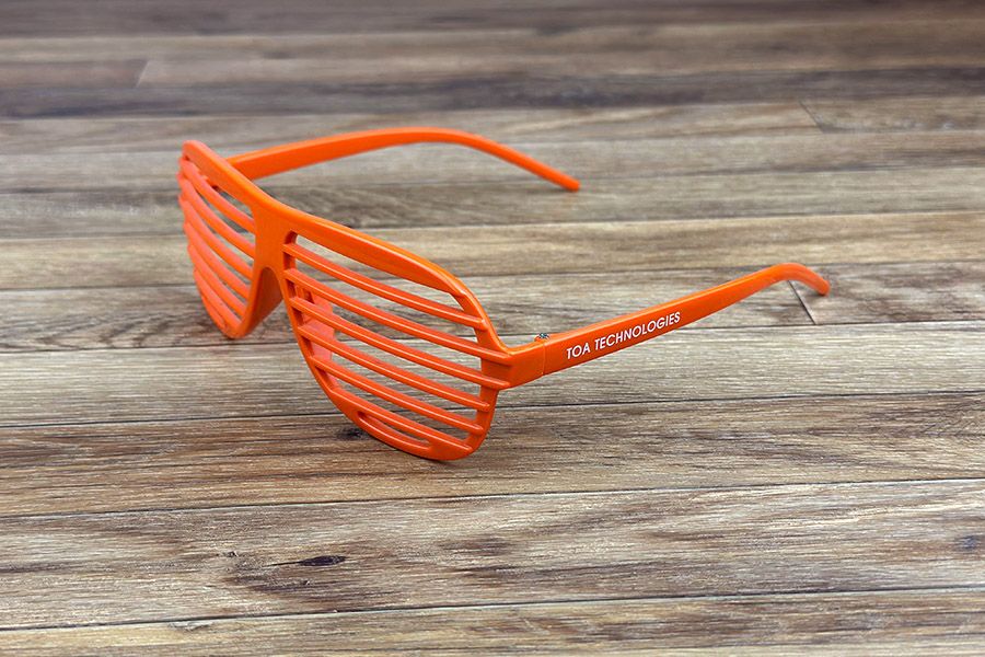 oranje zonnebril type shutters met een witte opdruk op de beentjes